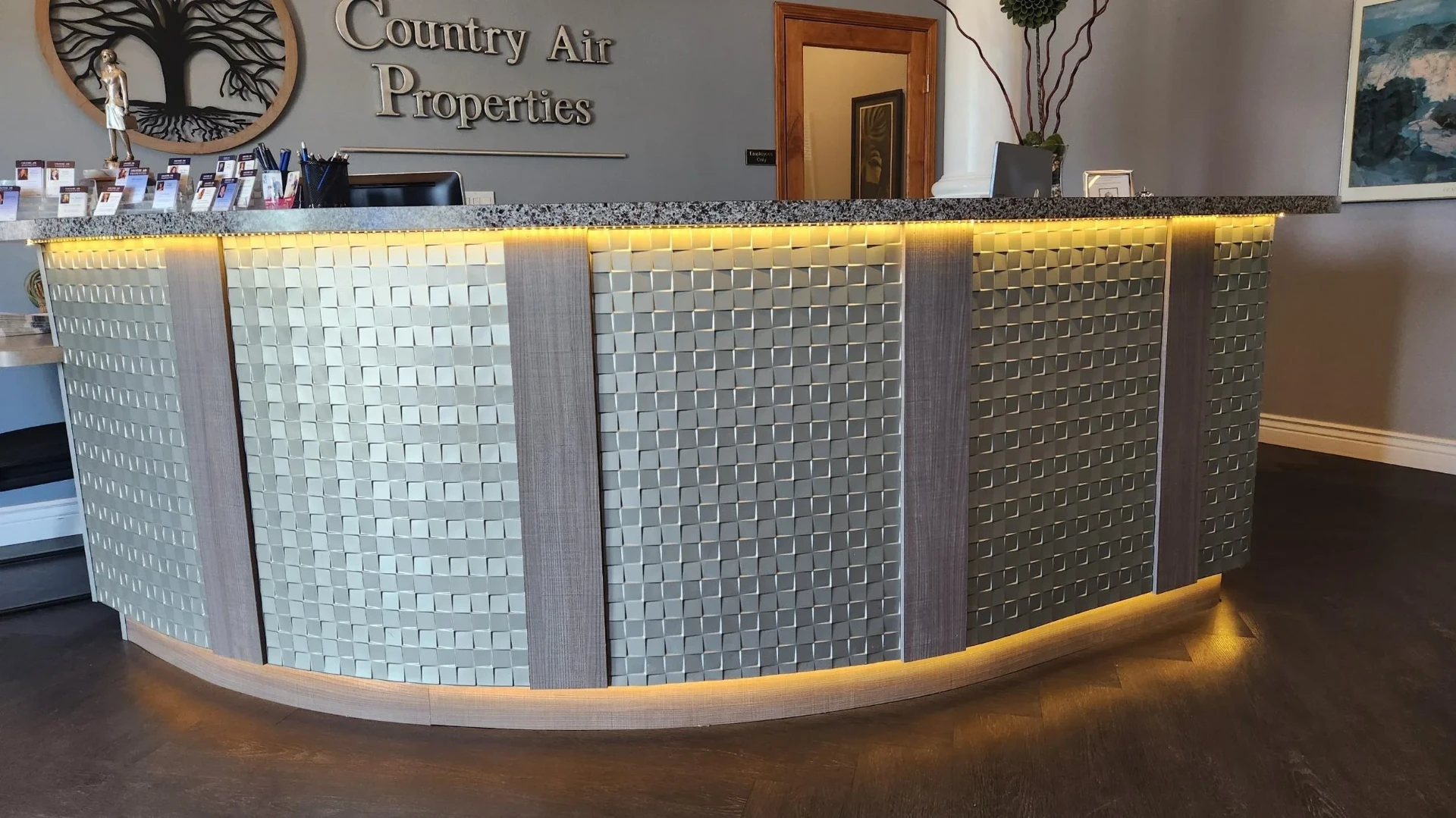 Country Air Properties reception with woven metal panel desk and LED accents