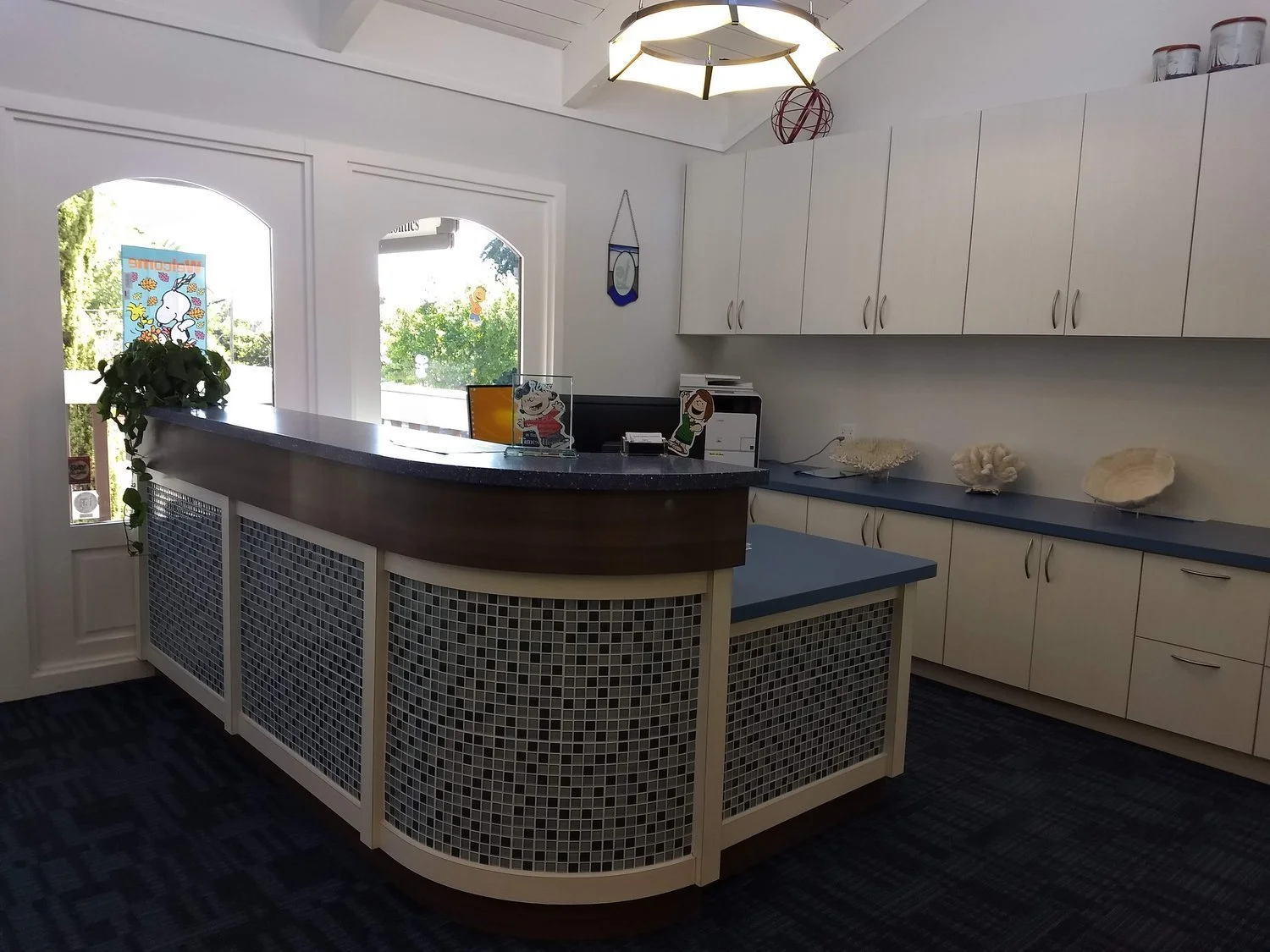 Coastal-themed dental reception with mosaic tile desk